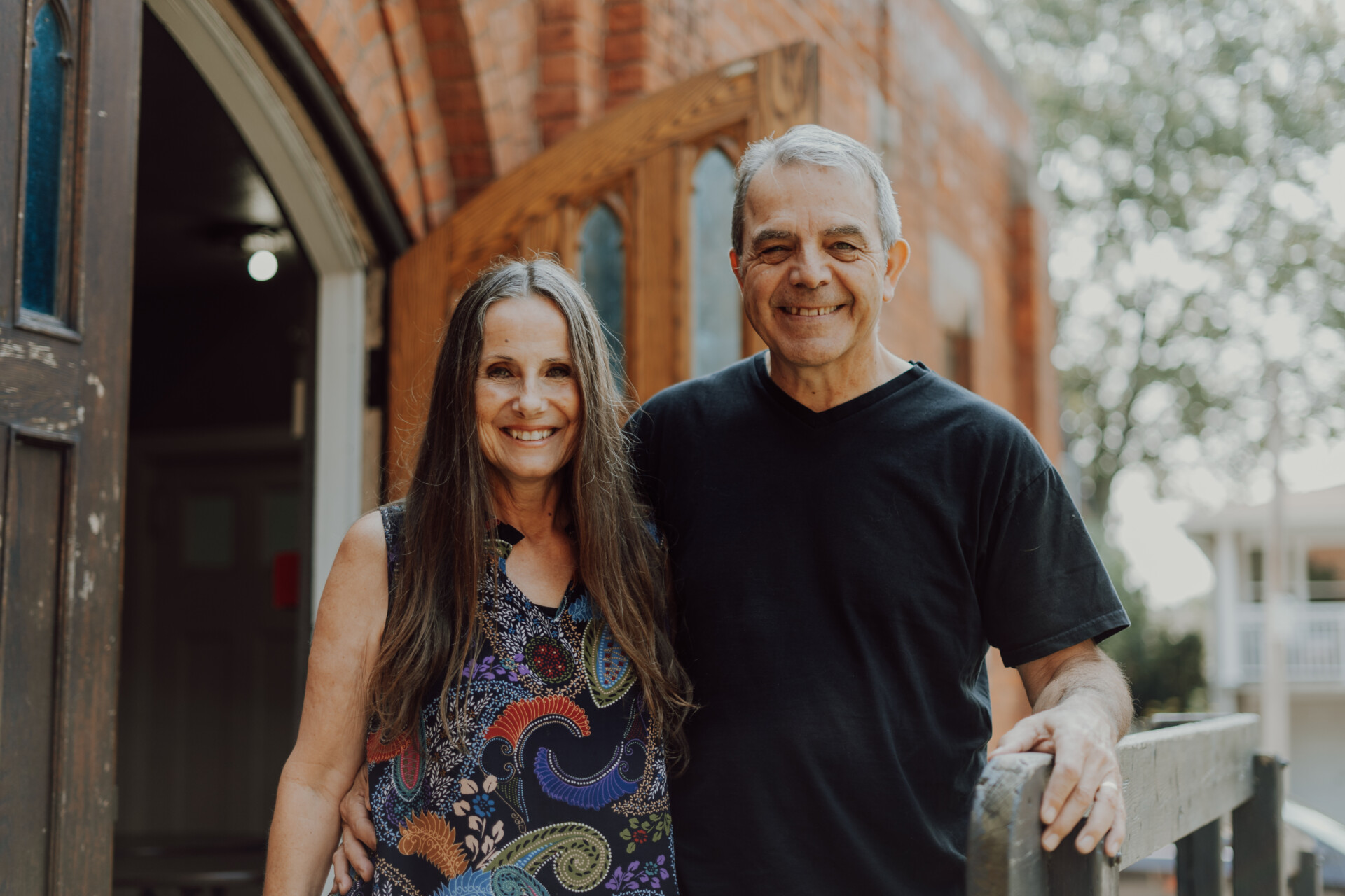 Bob & Lisa Cowling, Senior Leaders at HCF, standing in the front doorway of the church.